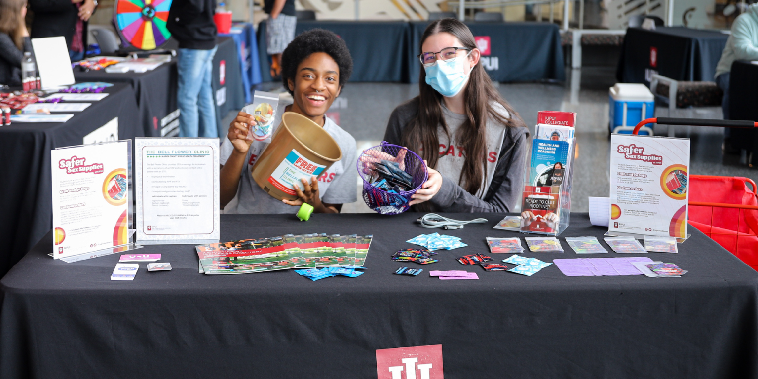 Students smiling while working at the HWP info table.